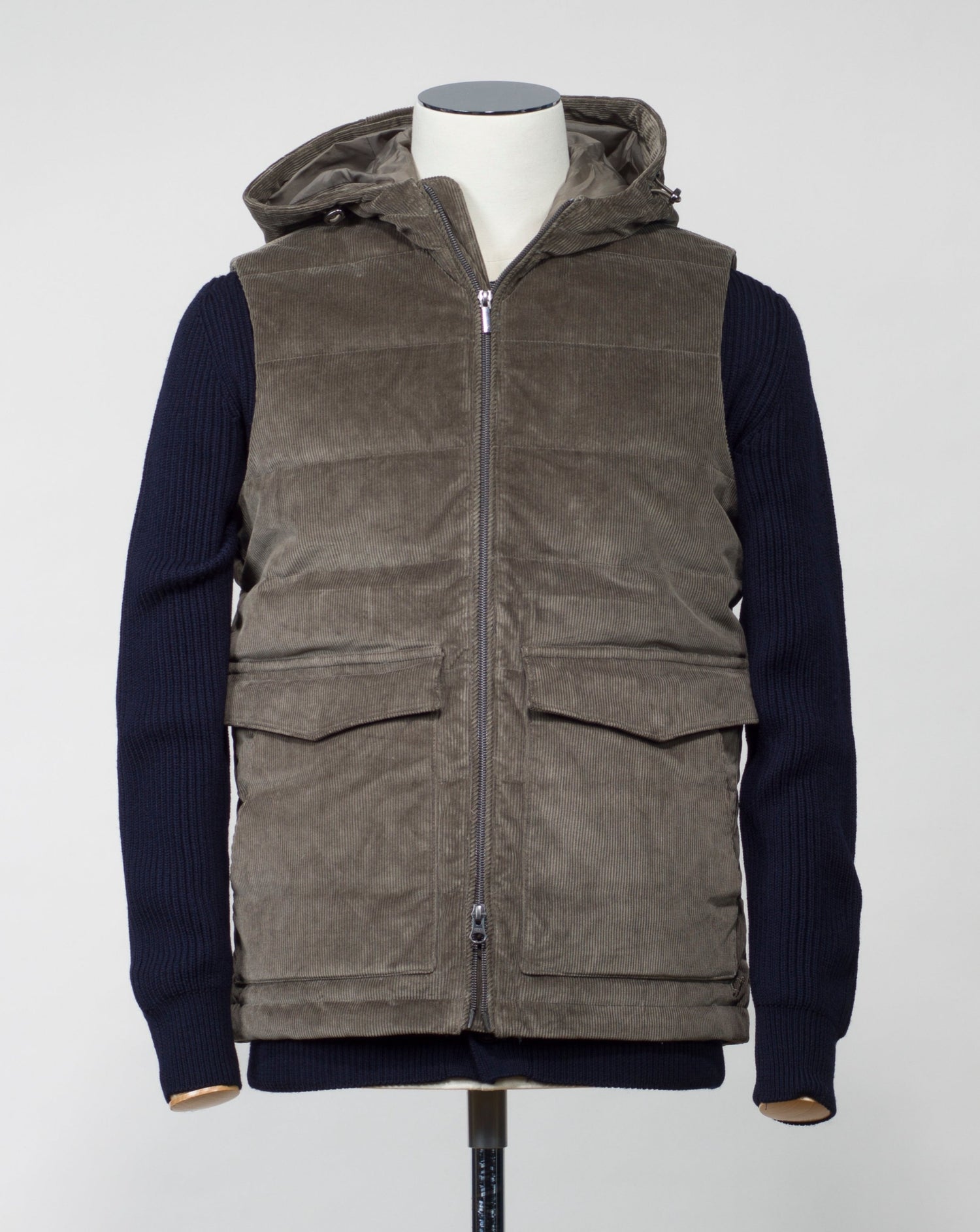 Fixed, adjustable hood Stenströms Corduroy Down Vest / Olive Two way zip in front 2 flapped pockets with snap fasteners in front 2 hand warming pocket  2 inside pockets Adjustable hem Article: 4300251995 Color: Olive / 370 Main fabric 98% cotton 2% spandex Filling 90% down 10% feather