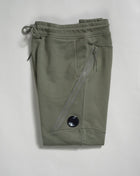 Sweatpants with an adjustable drawstring waistband and tapered legs. The sweatpants also feature slanted hand pockets and a C.P. Company Lens detail on the left leg. Crafted in diagonal raised fleece, a midweight loopback cotton option that combines absolute comfort with a substantial and hard-wearing feel.  14CMSP084A005086W Col 648 Bronze Green Adjustable drawstring waistband Slanted hand pockets Angular thigh zip pockets Lens detail Tapered leg