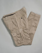 330 Sand / Cobblestone.P. Company Lens detail. Engineered in lightweight Stretch Sateen, a matte cotton textile with built-in extensibility, for a flexible and durable fit. Garment dyed for an increased chromatic depth and intensity throughout. Art. PA057A 5694G Col. 330 Cobblestone Belt loops Zip fly and button fastening Slanted hand pockets Two back pockets Two cargo pockets Lens detail Ergonomic fit slim fit cargo pants