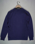 Crewneck sweatshirt featuring the C.P. Company Lens on the sleeve pocket. Manufactured in our diagonal raised fleece, a midweight loopback cotton option that combines absolute comfort with a substantial and hard-wearing feel. Art. SP084A 5086W Col. 868 Medieval Blue Ribbed Cuffs, Hem and Neck Lens Detail Sleeve Pocket Logo Detail Back Collar