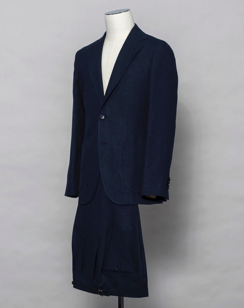 Slim fit Fits true to the size. If in doubt of your size, please contact us HERE Button closure 3 roll 2 buttoning, aka rollover Side vents 2 Patch pockets Composition:100%Linen 2 pleats in trousers front. Side Adjusters unfinished hem, needs to bee hemmed. Color: Navy / 6650 Linea: Gaiola Modello: GJ02 B2C Article: TP00808 Made in Naples, Italy