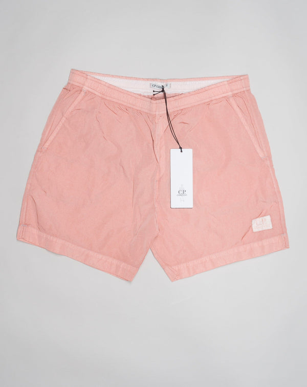 Eco-Chrome swim shorts constructed with an elasticated drawstring waist, hand pockets and a logo detail. Chrome is C.P. Company’s foundation woven multifilament nylon. This new version uses Econyl® regenerated nylon yarns, created through the upcycling of fishing nets.  Art. BW005A 6369G Col. 509 Pale Mauve Elasticated drawstring waist Hand pockets Logo detail Nylon dyed  