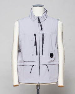 <ul> <li>Zip fastening in front. Two way zip.</li> <li>4 zipped pockets in front</li> <li>2 small pockets with snap fasteners in front</li> <li>1 pocket inside</li> <li>Adjustable hem</li> <li>Light weight hood inside collar</li> <li>Article: 16CMOW105A 005968A</li> <li>Composition: 92% Polyester 8% Elastan</li> <li>Color: 913 / Drizzle grey</li> <li>C.P. Company CP Shell Vest / Drizzle Grey</li> </ul>