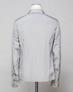 Button fastening in front. 2 breast pockets with buttons. Small pocket on left arm with snap fastener. Embroidered tone-on-tone C.P. Company logo on left pocket. Article: 16CMOS106A 005904G. Composition: 100% pre-consumer recycled nylon. Garment dyed. Color: 913 / Drizzle Grey
