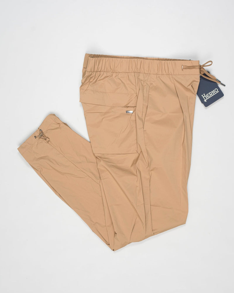 Trousers made of 20 denier stretch nylon whose weft and warp create a lightweight, matt and stretch fabric.
Comfortable to wear thanks to the drawstring that can be adapted to the desired fit, the style has a casual yet sophisticated feel that updates your everyday wardrobe.


Regular fit

Elastic with drawstring waist

Pleats at the front

Zip and button fastening

Slanted pockets

Patch pockets on the back

Drawstring at the ankles
Article: PT000041U 12431SZ
Color: Camel / 2157