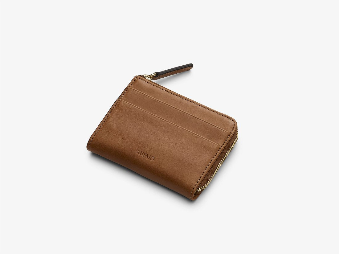 Measurements:  L: 10,2   H: 8   W: 2cm Body: Vegetable tanned full-grain cow leather Leather trimmings: Vegetable tanned full-grain cow leather Lining: Cotton/nylon stripe lining in off white/anthracite Zipper: YKK Excella Art. No. FG040218 A small and very practical zip wallet with the cardholders placed on the outside of large internal compartment that can be used just as easily for credit cards 