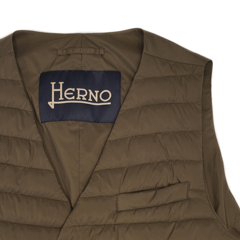 Herno In-Tech™ Alternative Down Waistcoat in Green. Great piece for layering.A true must have for every modern gentleman.  Wear it under jacket or over a knit. Great for traveling as it packs small and weighs almost nothing.   In-Tech™ Alternative Down Water Repellent  Breathable Light Insulation 5 buttons  3 pockets  Adjustable back External layer 100% Polyamide Internal padding 100% Polyester  PC0039U 19288 7745 Made in Romania  