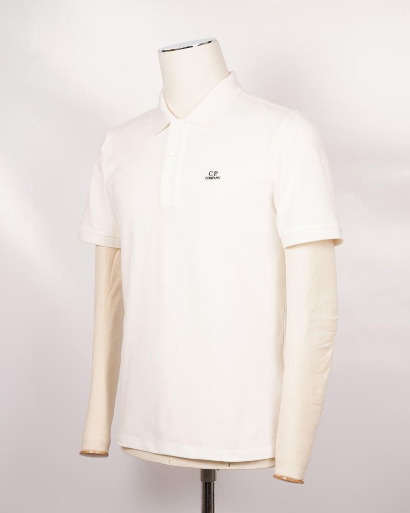 C.P. Company polo shirt in a short sleeve construction, featuring a two button placket, a classic collar, and the C.P. Company logo at the chest.  CP COMPANY Polo Short Sleeve MPL067A005263W Col. 103 Gauze White Composition: 100% cotton Classic Collar Two Button Placket Short Sleeves Embroidered Logo at Chest