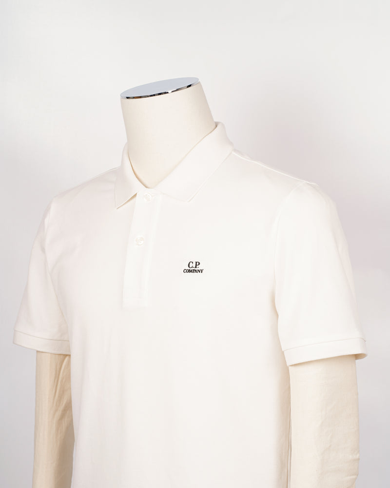 C.P. Company polo shirt in a short sleeve construction, featuring a two button placket, a classic collar, and the C.P. Company logo at the chest.  CP COMPANY Polo Short Sleeve MPL067A005263W Col. 103 Gauze White Composition: 100% cotton Classic Collar Two Button Placket Short Sleeves Embroidered Logo at Chest