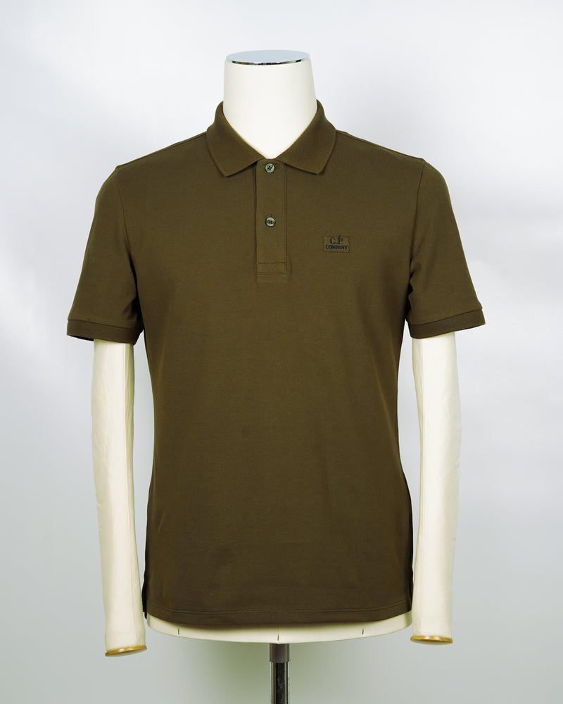 C.P. Company polo shirt in a short sleeve construction, featuring a two button placket, a classic collar, and the C.P. Company logo at the chest.  CP COMPANY Polo Short Sleeve MPL067A005263W Col. 683 Ivy Green Composition: 100% cotton Classic Collar Two Button Placket Short Sleeves Embroidered Logo at Chest