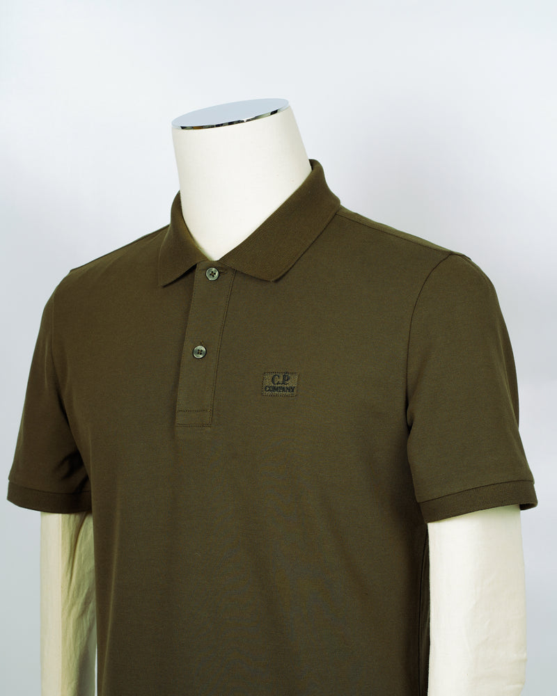C.P. Company polo shirt in a short sleeve construction, featuring a two button placket, a classic collar, and the C.P. Company logo at the chest.  CP COMPANY Polo Short Sleeve MPL067A005263W Col. 683 Ivy Green Composition: 100% cotton Classic Collar Two Button Placket Short Sleeves Embroidered Logo at Chest