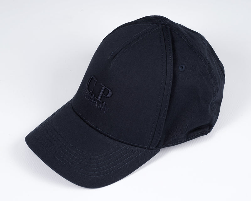 Men´s cotton gabardine cap with embroidered C.P. -logo in front, adjustable strap in the back and tone on tone stitchings  and detailing. A classic six panel structure.  Crafted in a classic six panel style, this men's cap features a curved brim, tonal- Curved Brim Embroidered Logo Stitched Detailing Six Panel Construction Adjustable Strap Mod. MAC091A00 5279A Col. 888 / Total eclipse