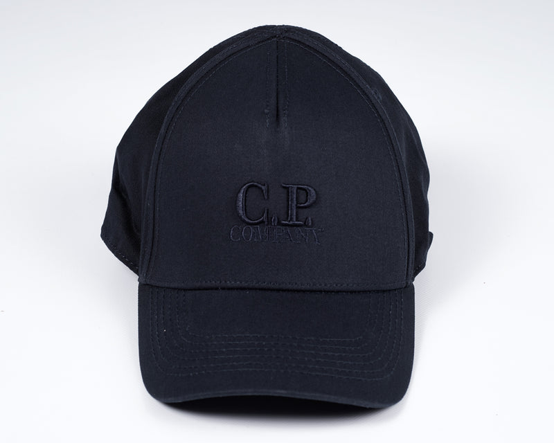 Men´s cotton gabardine cap with embroidered C.P. -logo in front, adjustable strap in the back and tone on tone stitchings  and detailing. A classic six panel structure.  Crafted in a classic six panel style, this men's cap features a curved brim, tonal- Curved Brim Embroidered Logo Stitched Detailing Six Panel Construction Adjustable Strap Mod. MAC091A00 5279A Col. 888 / Total eclipse