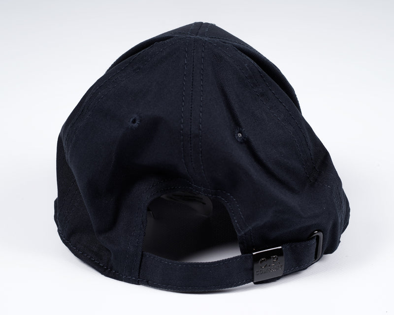 Men´s cotton gabardine cap with embroidered C.P. -logo in front, adjustable strap in the back and tone on tone stitchings  and detailing. A classic six panel structure.  Crafted in a classic six panel style, this men's cap features a curved brim, tonal- Curved Brim Embroidered Logo Stitched Detailing Six Panel Construction Adjustable Strap Mod. MAC091A00 5279A Col. 888 / Total eclipse