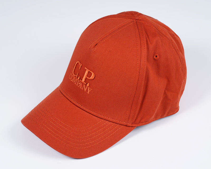 Men´s cotton gabardine cap with embroidered C.P. -logo in front, adjustable strap in the back and tone on tone stitchings  and detailing. A classic six panel structure. Embroidered Logo Stitched Detailing Six Panel Construction Adjustable Strap Mod. MAC091A00 5279A Col. 468 / Burnt Ochre