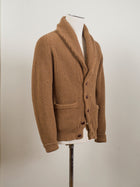 Drake's shawl collar cardigan made up in a soft lambswool. Wear it as an alternative to your tailored jacket on more casual days, or thrown over just about anything: its beauty is its versatility. 100% Lambswool Brown Knotted Leather Buttons Color: Camel KNI-64LAM-20818-002 Made in Scotland