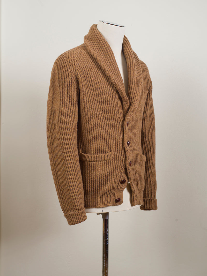 Drake's shawl collar cardigan made up in a soft lambswool. Wear it as an alternative to your tailored jacket on more casual days, or thrown over just about anything: its beauty is its versatility. 100% Lambswool Brown Knotted Leather Buttons Color: Camel KNI-64LAM-20818-002 Made in Scotland