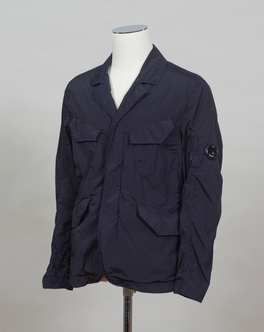 ed into a fibre fine enough to be used to weave Nycra.   CP Blazer  Nycra R MBZ250A00 5864G 888 Total Eclipse / Dark Blue 2 way zip + press studs in front 4 pockets in front with snap stud fastening Zippered pocket on left sleeve with C.P. Lens detailing Garment Dyed Quick Dry Stretch Multi filament