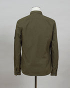 A buttoned shirt featuring a classic collar, secure pockets at the chest, and a discreet sleeve compartment finished with the C.P. Company Lens detail.  Classic Collar Full Button Fastening Secure Chest Pockets Lens Detail Sleeve Pocket Col. 683 / Ivy Green 100% Cotton Art. 12CMSH088A 002824G