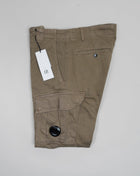 Button Fastening Belt Loops Slanted Hand Pockets Twin Cargo Pockets Back Pockets Lens Detail Garment Dyed 98% Cotton 2% Elastane Art. 12CMPA056A005694G Col. 322 Seneca Rock / Khaki Green Wash max 30°C - Mild process Functional men's cargo pants crafted with a fitted leg, featuring reinforced belt loops, slanted hand pockets, and secure cargo compartments at each leg. Finished with the C.P. Company Lens detail