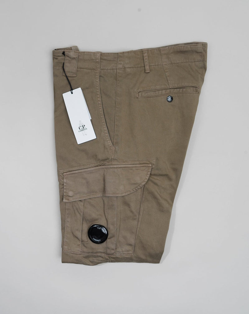 Button Fastening Belt Loops Slanted Hand Pockets Twin Cargo Pockets Back Pockets Lens Detail Garment Dyed 98% Cotton 2% Elastane Art. 12CMPA056A005694G Col. 322 Seneca Rock / Khaki Green Wash max 30°C - Mild process Functional men's cargo pants crafted with a fitted leg, featuring reinforced belt loops, slanted hand pockets, and secure cargo compartments at each leg. Finished with the C.P. Company Lens detail