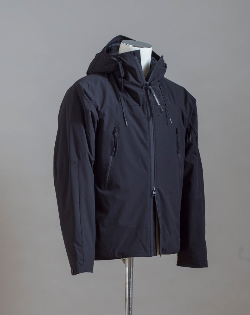C.P. Company Pro-Tek Hooded Jacket that combines the weight and comfort of a sweatshirt with the protective functions of an outer layer. Water resistant coating on the upper layer of the jacket. Art. 13CMOW025A 004117A Col. 999 / Black Zippered pocket  Pocket with C.P. Company Lens on the left arm Adjustable hood and hem Water resistant