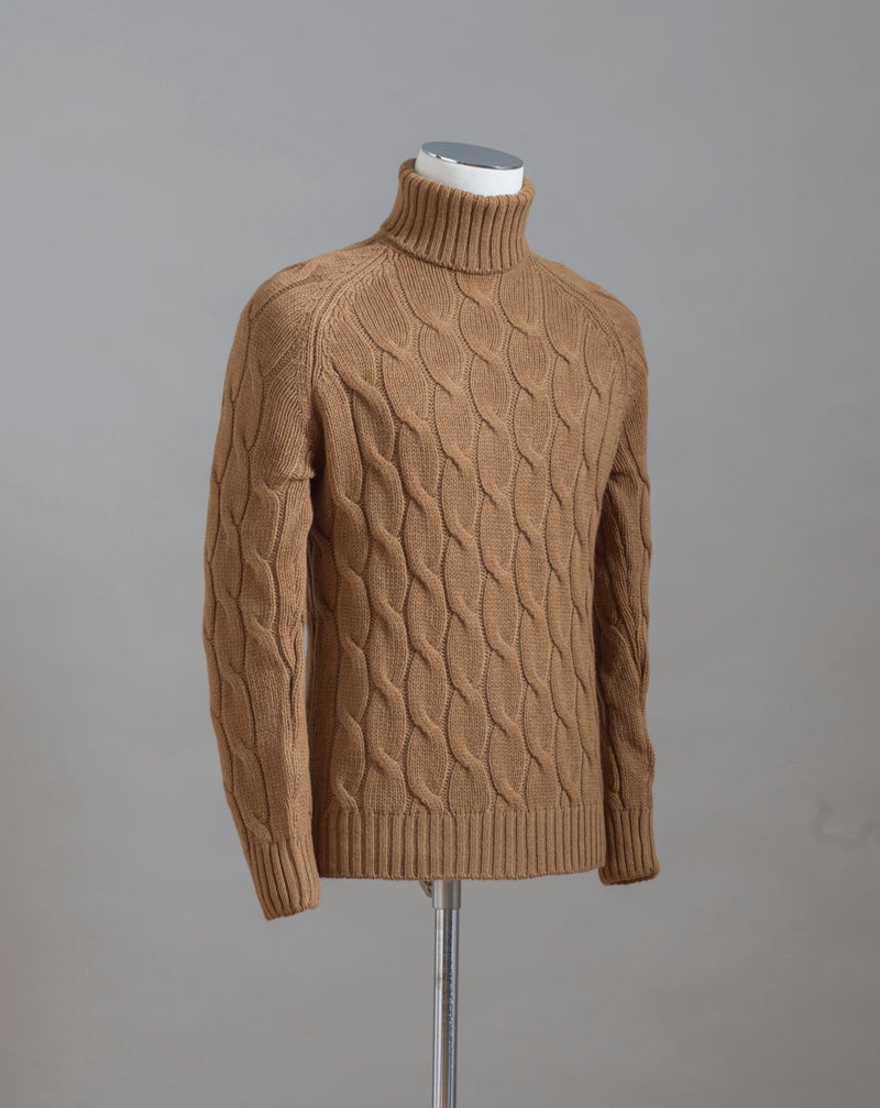 Gran Sasso cable knit roll neck made of special 3-ply Air Wool quality. The special feature of this garment is the yarn that holds microscopic air bubbles between the fibers, making it at the same time warm and light.  Art.  13117/22622 Col.  117 / Tobacco 100% Wool Made in Italy 