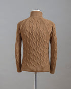 Gran Sasso cable knit roll neck made of special 3-ply Air Wool quality. The special feature of this garment is the yarn that holds microscopic air bubbles between the fibers, making it at the same time warm and light.  Art.  13117/22622 Col.  117 / Tobacco 100% Wool Made in Italy 