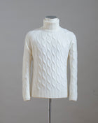 Gran Sasso cable knit roll neck made of special 3-ply Air Wool quality. The special feature of this garment is the yarn that holds microscopic air bubbles between the fibers, making it at the same time warm and light.  Art.  13117/22622 Col.  005 / Natural White 100% Wool Made in Italy 