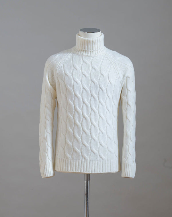 Gran Sasso cable knit roll neck made of special 3-ply Air Wool quality. The special feature of this garment is the yarn that holds microscopic air bubbles between the fibers, making it at the same time warm and light.  Art.  13117/22622 Col.  005 / Natural White 100% Wool Made in Italy 