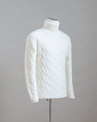 Gran Sasso cable knit roll neck made of special 3-ply Air Wool quality. The special feature of this garment is the yarn that holds microscopic air bubbles between the fibers, making it at the same time warm and light.  Art.  13117/22622 Col.  005 / Natural White 100% Wool Made in Italy 