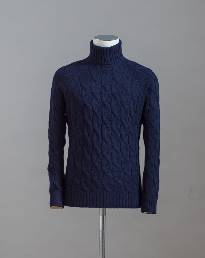 Gran Sasso cable knit roll neck made of special 3-ply Air Wool quality. The special feature of this garment is the yarn that holds microscopic air bubbles between the fibers, making it at the same time warm and light.  Art.  13117/22622 Col. 598 Navy 100% Wool Made in Italy 