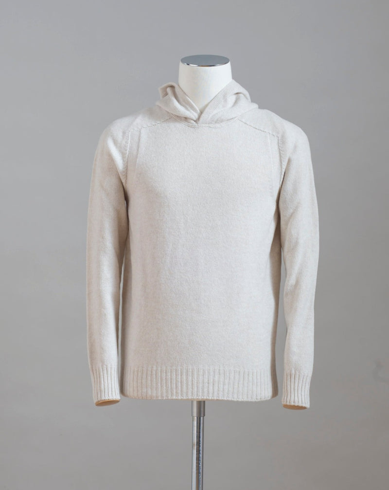Hooded stitch sweater in Super Geelong wool. A sporty garment that you can match with jeans for an urban look or with jogging-style trousers for a sporty and refined outfit. Geelong wool has as soft touch as cashmere, yet it is remarkably durable. One of the best wool qualities you can find.  Hooded Sweater 100% Wool  Ribbed hem and cuffs Article:  24171/25024 Colore: 054 / Panna Made in Italy