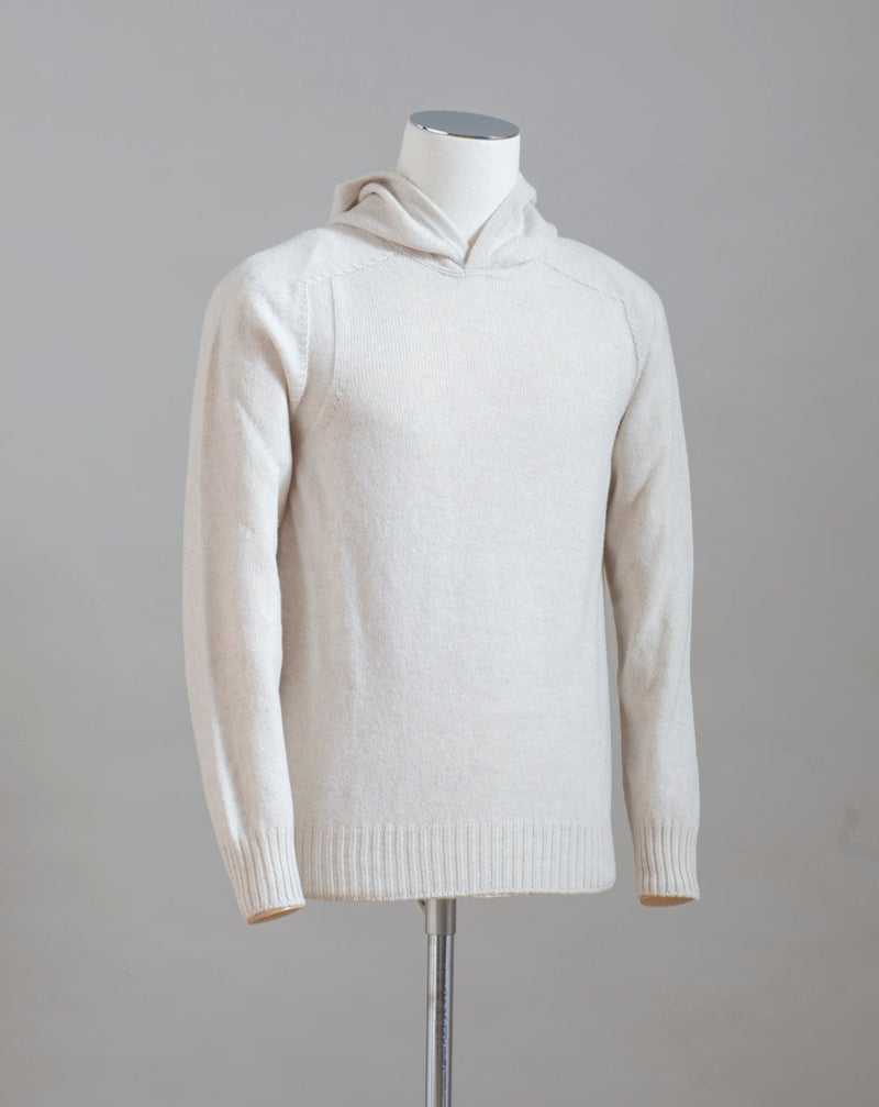 Hooded stitch sweater in Super Geelong wool. A sporty garment that you can match with jeans for an urban look or with jogging-style trousers for a sporty and refined outfit. Geelong wool has as soft touch as cashmere, yet it is remarkably durable. One of the best wool qualities you can find.  Hooded Sweater 100% Wool  Ribbed hem and cuffs Article:  24171/25024 Colore: 054 / Panna Made in Italy