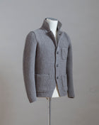 Heavy ribbed jacket made of 5-Ply Super Geelong wool. Geelong wool has as soft touch as cashmere, yet it is remarkably durable. Elegant, comfortable and practical wool quality, perfect for a chunky garment like this.  100% Geelong wool 3 Patch pockets 3 Buttons Mod.  10166/25028 Col. 017 / Taupe (brown-gray) Made i Italy