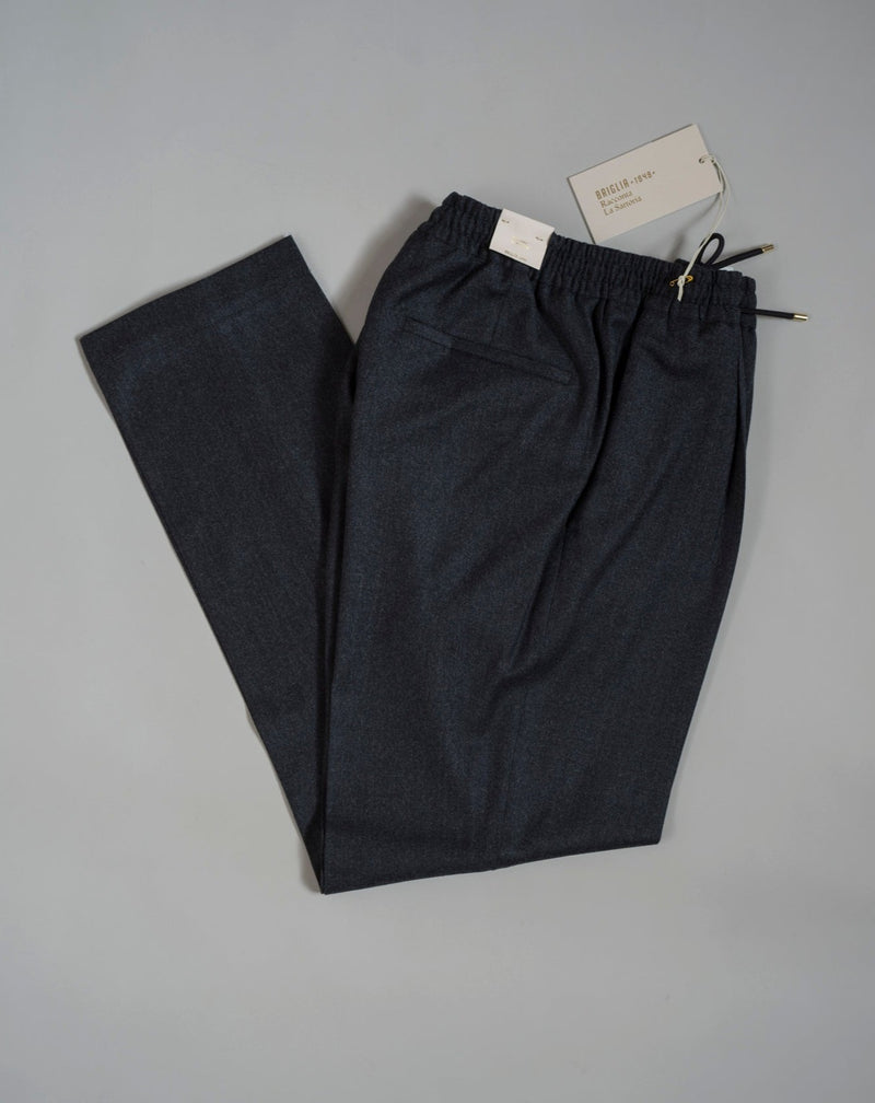 Wool flannel drawstring trousers by Briglia 1949. Next level comfort and style in one package. Fits true to the size. If in doubt of your size, please contact us HERE Single pleat 100% Wool  Drawstring Slanted side pockets 2 back pockets Plain hem Model: Wimbledons Art: 422129 Col: 00090 / Dark Grey Made in Naples, Italy