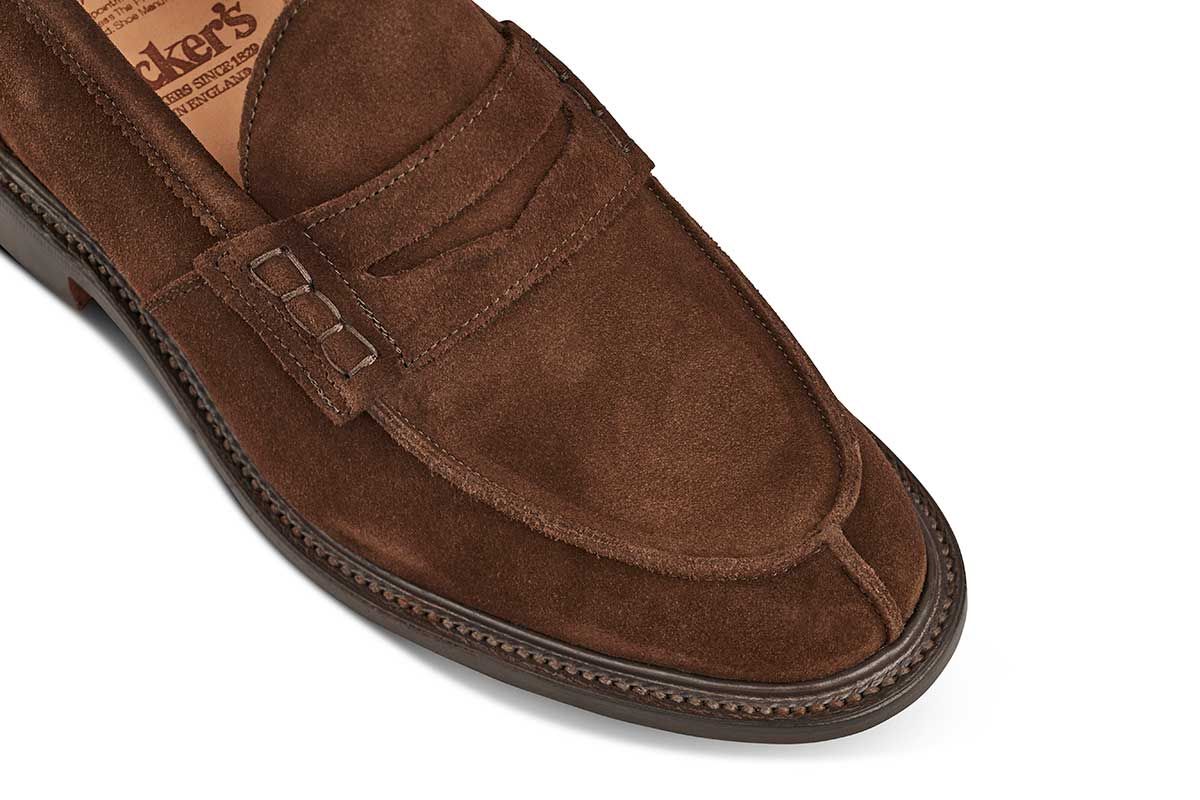 Tricker’s classic step in Penny loafer combines comfort with quiet confidence. In chocolate Repello suede with storm welt, leather uppers and linings for even greater refinement, channelled and stitched leather sole. Tricker's James Suede Penny Loafer / Chocolate