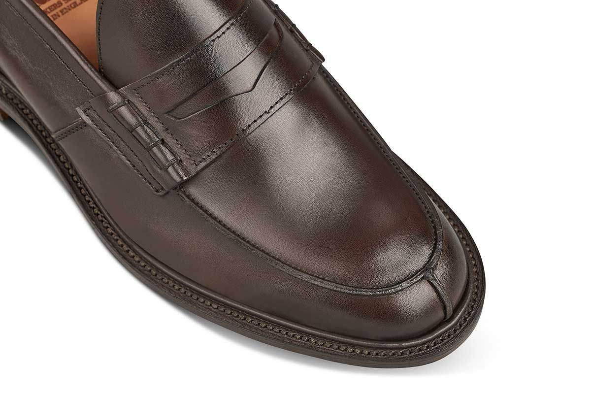 Tricker’s classic step in Penny loafer combines comfort with quiet confidence. In Espresso with Brown storm welt, leather uppers and linings for even greater refinement, channelled and stitched leather sole. Tricker's James Penny Loafer / Espresso