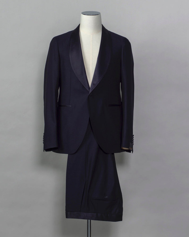 Tagliatore tuxedo with shawl collar.  Unconstructed shoulder and half lined inside construction on jacket. Flat front trousers with satin waistband, matching to jacket lapel. Composition: 99% Virgin Wool Super 110's 1% Elastan Stretch Modello: S-PL18A01 LIS Color: Navy / B270 Unconstructed Unlined 1 button Shawl collar Jet pockets Back vent Flat front Made in Martina Franca, Italy