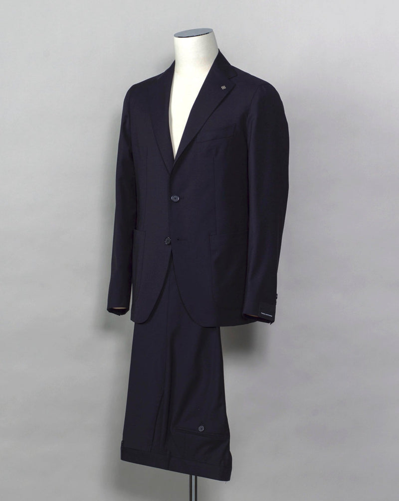 Tagliatore single breasted suit with unconstructed shoulder and unlined inside structure. Relaxed and comfortable, but at the same time look remains very smart and sharp. Composition: 99% Virgin Wool Super 110's 1% Elastan Stretch Modello: 2SMC22K01 Color: Navy / B5092 Unconstructed Unlined 2 Buttons Notch lapel Patch pockets Side vents Flat front Belt loops Made in Martina Franca, Italy