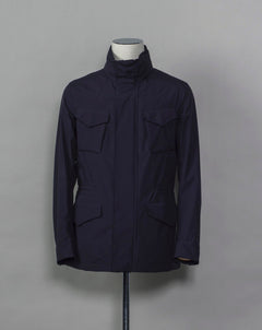 Montecore waterproof field jacket. Four pockets in front and adjustable waistband. Adjustable hood that can be folded inside the collar. So all the classical elements of a proper field jacket plus the added value of a waterproof and breathable technical  material. Four pockets in front Adjustable waist band Adjustable hood inside the collar Waterproof Breathable Taped seams  79% Polyester 21% Polyurethane Art. S04MUCT603 Col. 89 / Navy