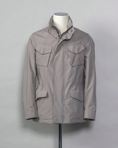  Montecore waterproof field jacket. Four pockets in front and adjustable waistband. Adjustable hood that can be folded inside the collar. So all the classical elements of a proper field jacket plus the added value of a waterproof and breathable technical  material. Four pockets in front Adjustable waist band Adjustable hood inside the collar Waterproof Breathable Taped seams 79% Polyester 21% Polyurethane Art. S04MUCT603 Col. 23 / Stone Grey