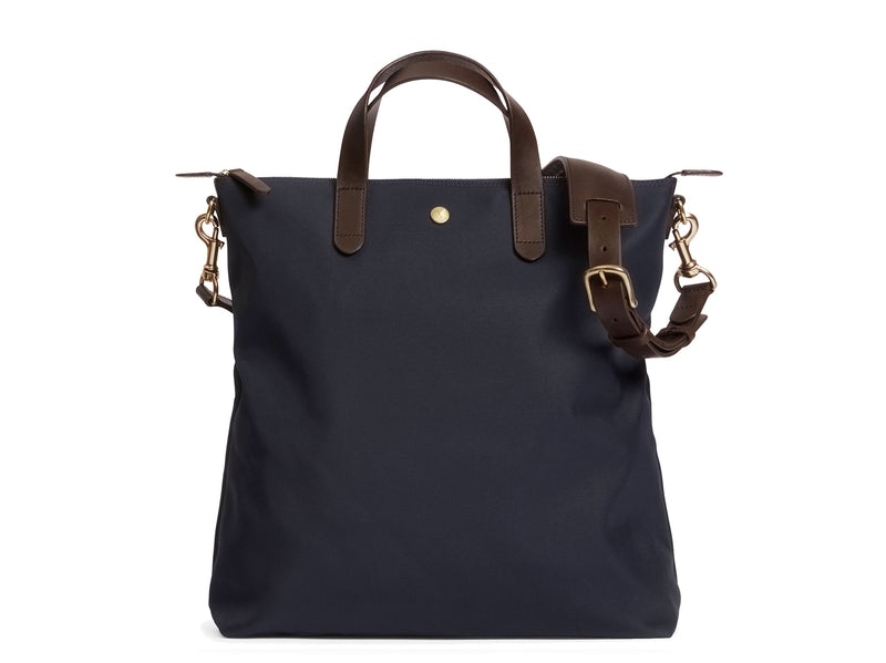Measurements:  L: 37 x H: 41 x W: 10 cm Fabric composition: PA 42% CO 38% PU 20%  /  826g pr. meter  Body: Waterproof hard woven Italian nylon Trimmings:  Custom developed dark brown vegetable tanned full-grain bridle leather Lining: 100% cotton in navy colour Hardware: Solid brass with varnish protection  Zipper: Hand polished YKK Excella Art. No. MS251312 As the first style ever launched in the Contemporary collection, the M/S Shopper has grown to become one of the most iconic styles of the Mismo 