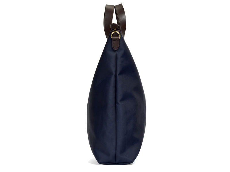 Measurements:  L: 37 x H: 41 x W: 10 cm Fabric composition: PA 42% CO 38% PU 20%  /  826g pr. meter  Body: Waterproof hard woven Italian nylon Trimmings:  Custom developed dark brown vegetable tanned full-grain bridle leather Lining: 100% cotton in navy colour Hardware: Solid brass with varnish protection  Zipper: Hand polished YKK Excella Art. No. MS251312 As the first style ever launched in the Contemporary collection, the M/S Shopper has grown to become one of the most iconic styles of the Mismo 