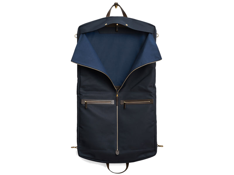 Measurements: L: 52 x W: 50 x H: 7 cm Body: Waterproof hard woven Italian nylon Fabric composition: PA 42% CO 38% PU 20% / 826g /m Trimmings: Dark brown custom developed vegetable tanned full-grain bridle leather Lining: 100% cotton in navy colour Hardware: Solid brass with varnish protection Zipper: Hand polished YKK Excella Art. No. MS441315 Transporting your work, wedding, and/or weekend wear just got a whole lot easier. Slip garments into first ever full size garment bag large to carry all mismo