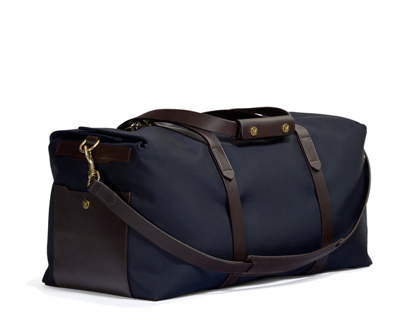 Measurements: L: 52 H: 25 W: 28(26) cm Body: Waterproof hard woven Italian nylon Fabric composition: PA 42% CO 38% PU 20% / 826g/m Trimmings: Dark brown custom developed vegetable tanned full-grain bridle leather Lining: 100% cotton in navy colour Hardware: Solid brass with varnish protection Zipper: Hand polished YKK Excella Art. No. MS411315 Travel, gym, tennis life’s adventures take the M/S Supply is a great addition. Elongated handles easy to carry bag by hand, hung over shoulder worn rucksack